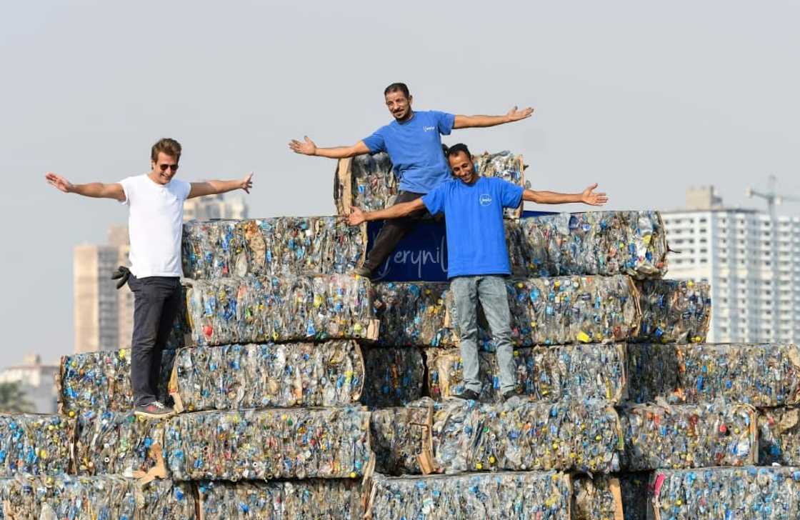 Environmental volunteers stand atop a pyramid of compressed plastic waste collected from the Nile, in Giza near the capital on "World Cleanup Day", September 17, 2022 Environmental volunteers stand atop a pyramid of compressed plastic waste collected from the Nile, in Giza near the capital on "World Cleanup Day", September 17, 2022