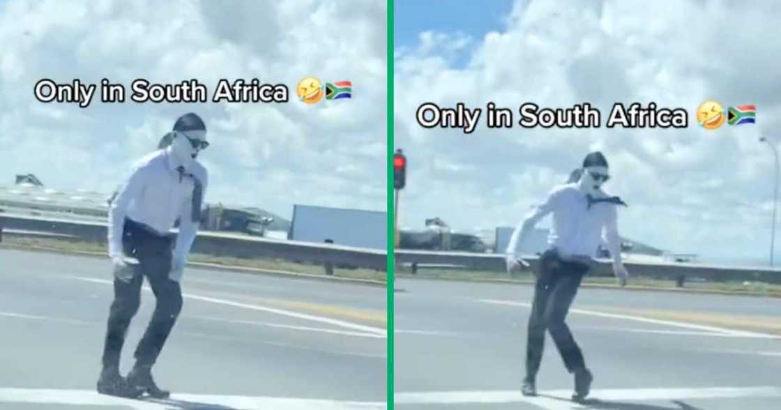 A man painted in white dances at the intersection A man painted in white dances at the intersection