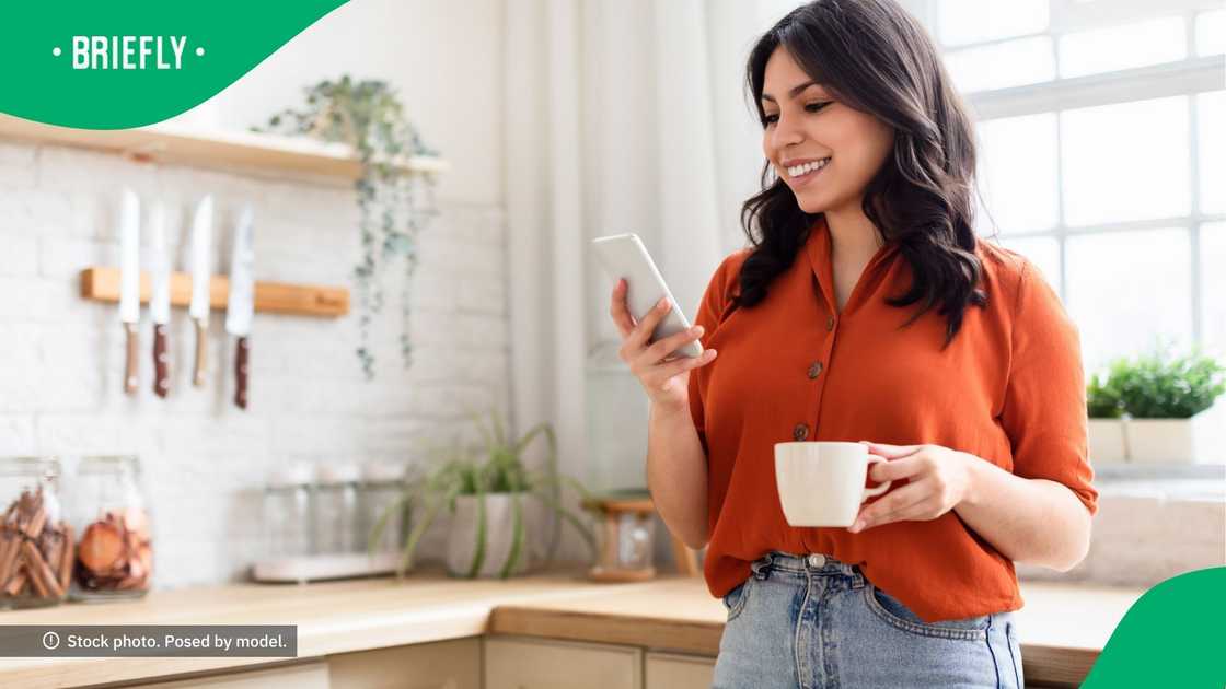 A woman smiling at her phone. A woman smiling at her phone.