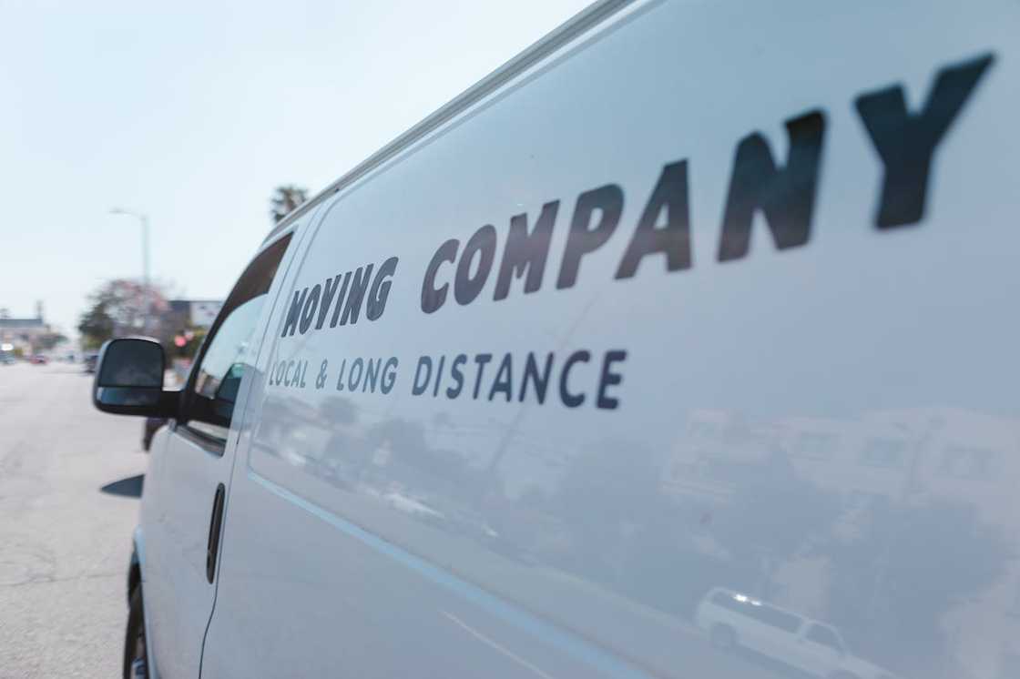 White van branded "Moving Company – Local & Long Distance" parked on a street.