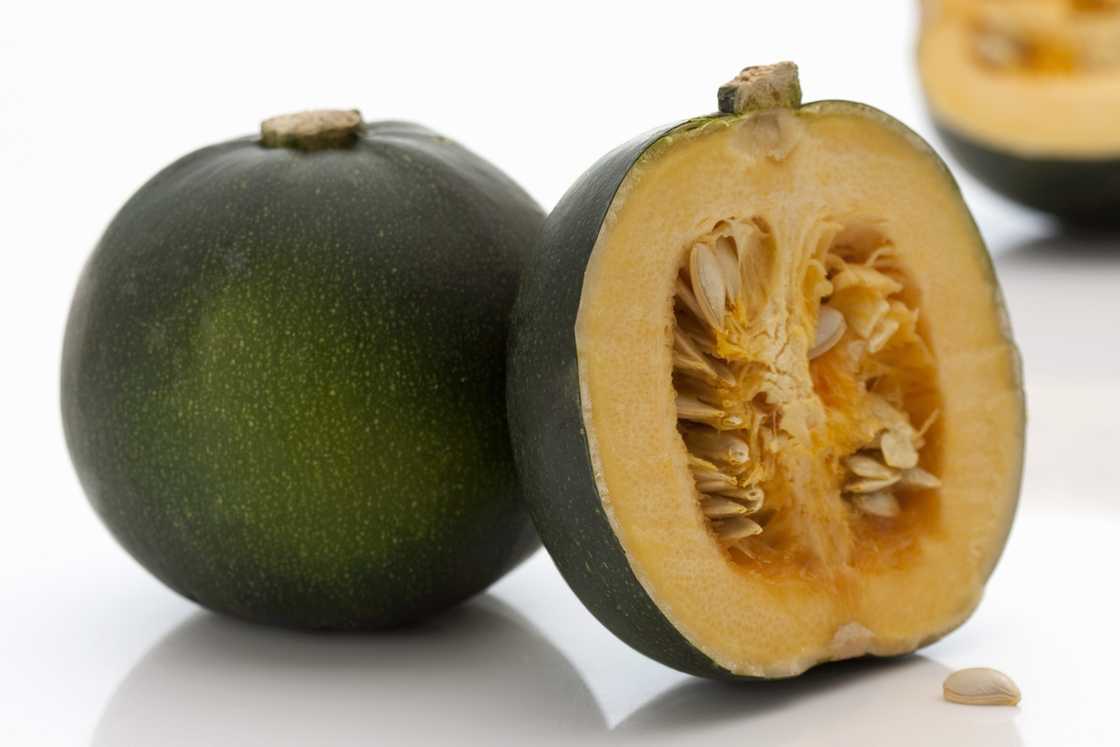 A whole and halved gem squash.