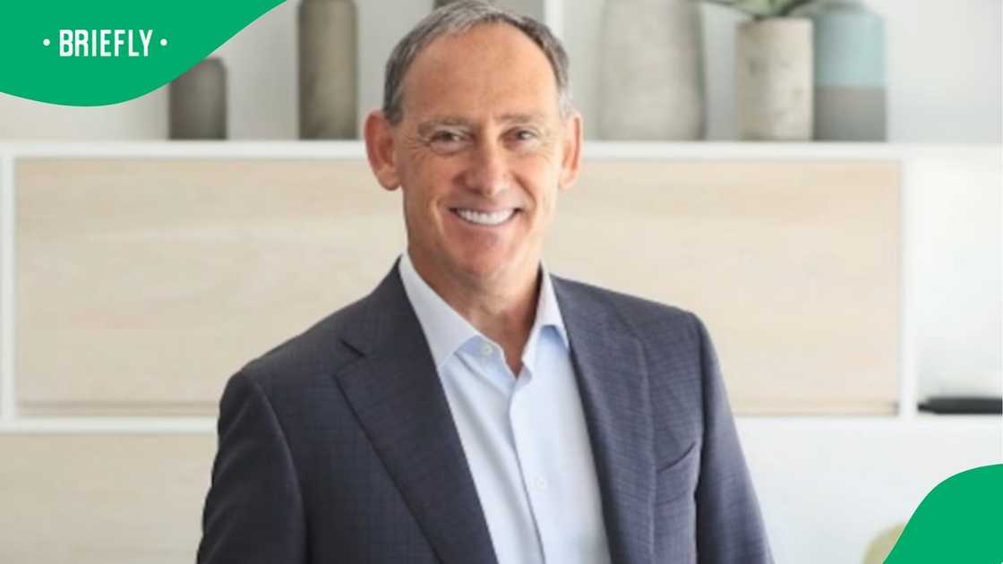 The professionally lit photograph captured corporate leader Roy Bagattini standing confidently before a bright, minimalist office shelf display. The professionally lit photograph captured corporate leader Roy Bagattini standing confidently before a bright, minimalist office shelf display.
