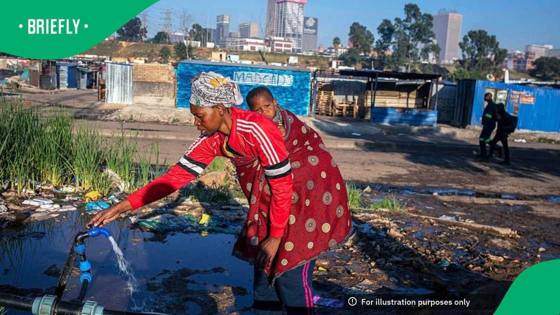 A woman fetches water at tap in an informal settlement area on the outskirts of the city on November 1, 2025 in central Johannesburg, South Africa
