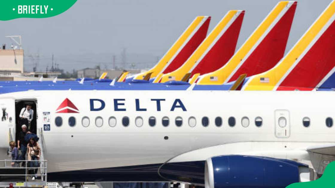 Travellers disembark from a Delta Air Lines flight