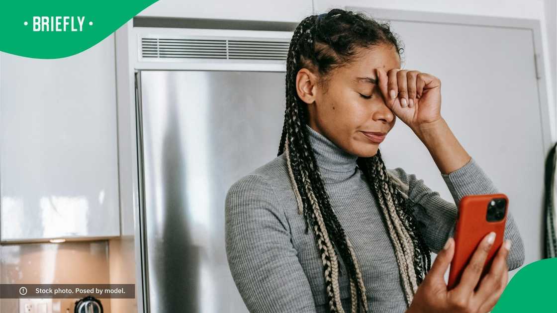 An upset woman looking at her phone.