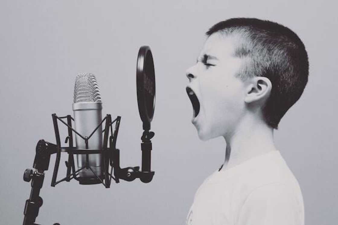 A child on a microphone with a pop filter