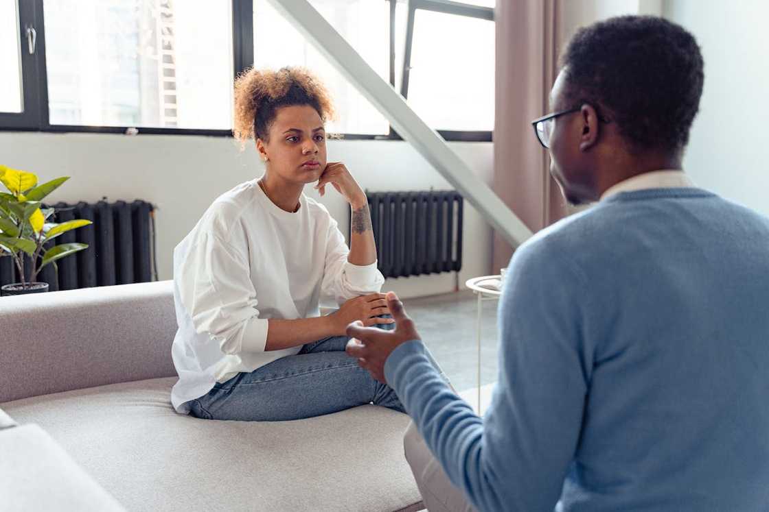 A woman listens to a man during a serious discussion. A woman listens to a man during a serious discussion.