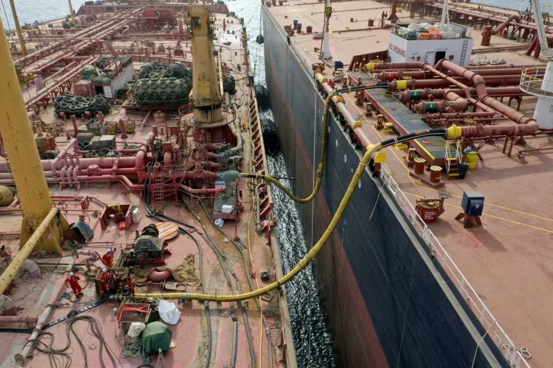 Workers prepare to transfer oil  from the 47-year-old supertanker FSO Safer (L) to a UN-purchased replacement vessel in a bid to avert a catastrophic spill in the Red Sea off war-torn Yemen