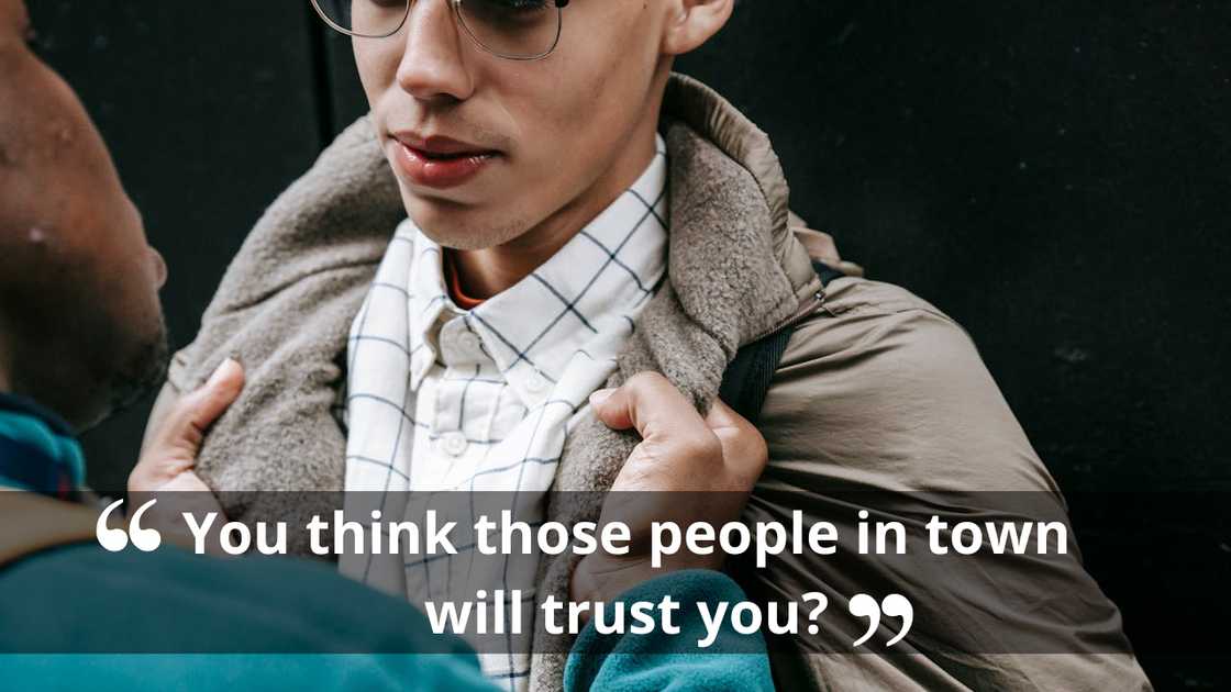 A man grips another man's jacket collar during a tense confrontation.