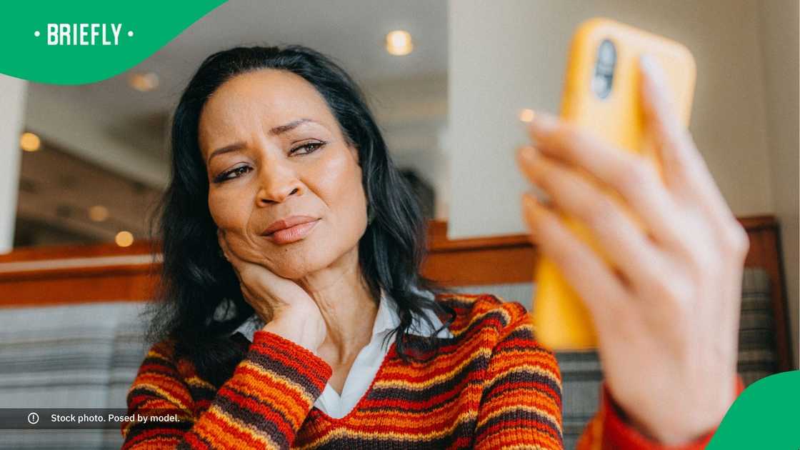 A confused woman looking at her phone. A confused woman looking at her phone.