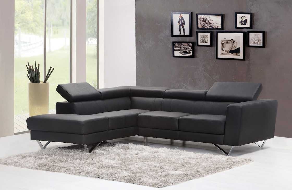 A black fabric sectional sofa near a glass window A black fabric sectional sofa near a glass window