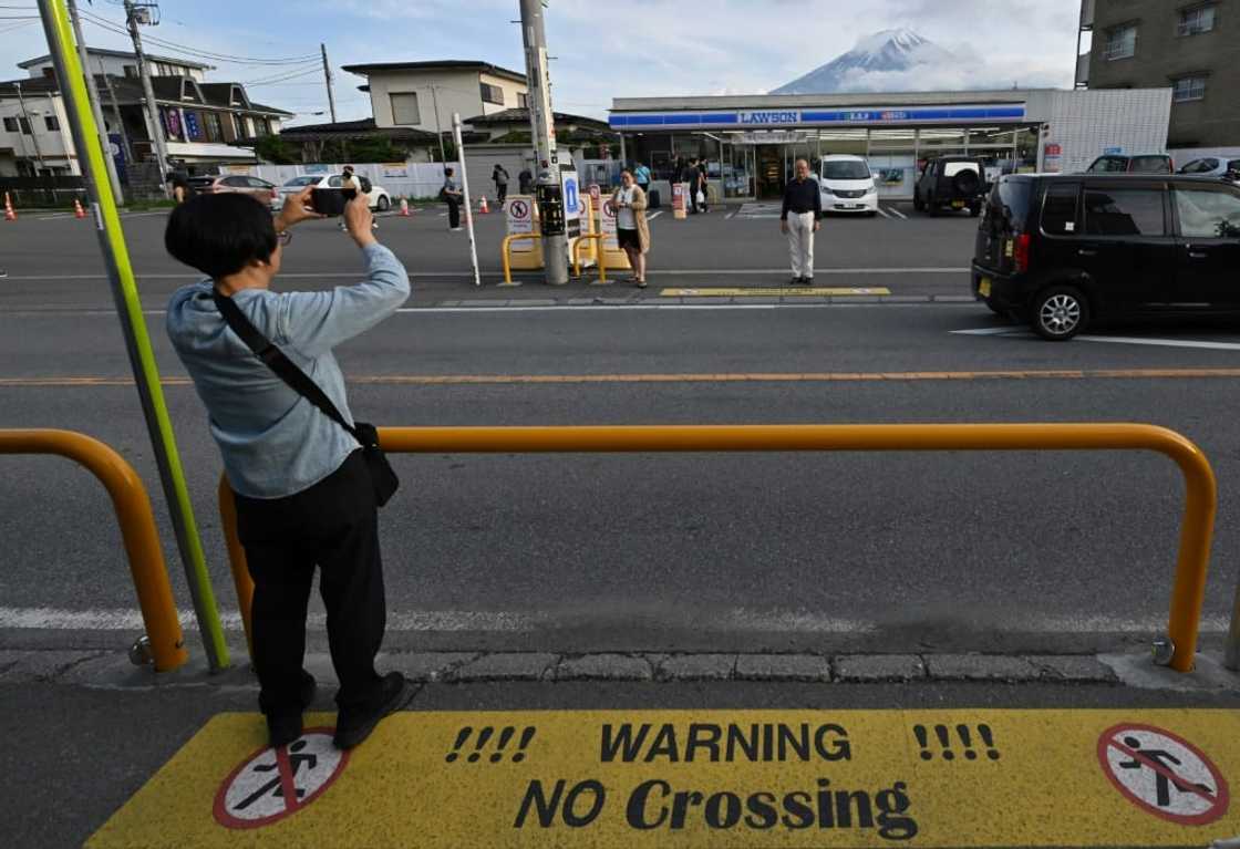 A tourist takes pictures of Mount Fuji in the town of Fujikawaguchiko, Yamanashi prefecture A tourist takes pictures of Mount Fuji in the town of Fujikawaguchiko, Yamanashi prefecture