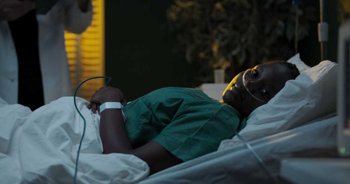 A mother in bed looks towards an empty baby cot. A mother in bed looks towards an empty baby cot.