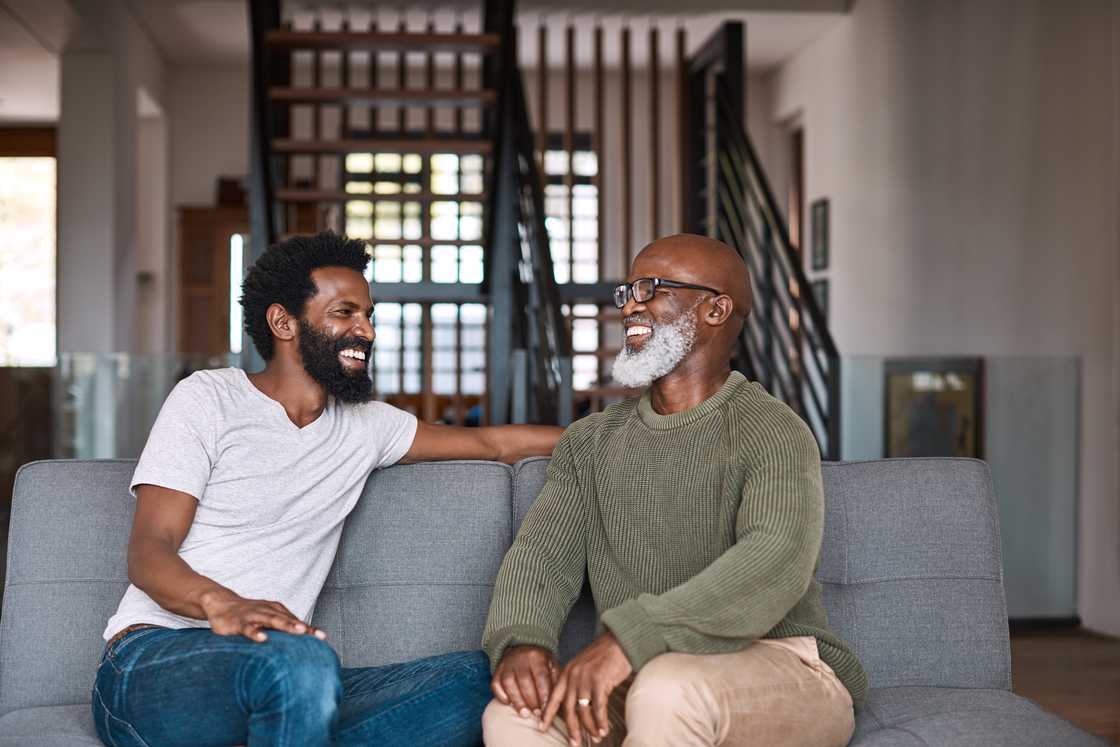 A happy young man relaxing and spending time with his father at home