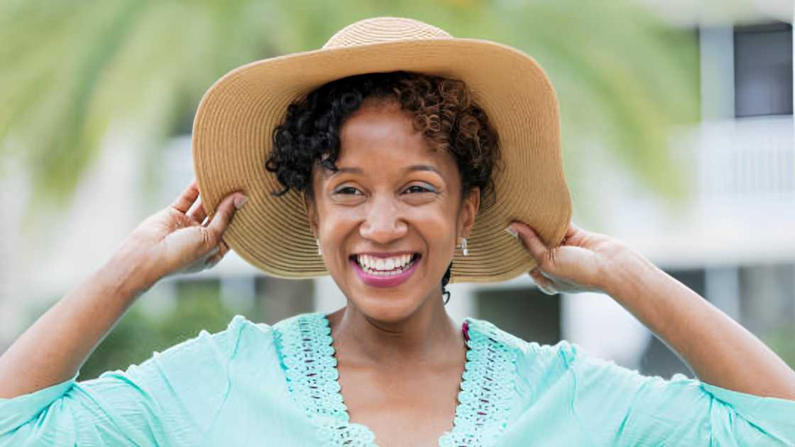 A woman wearing a wide brim sun hat. A woman wearing a wide brim sun hat.