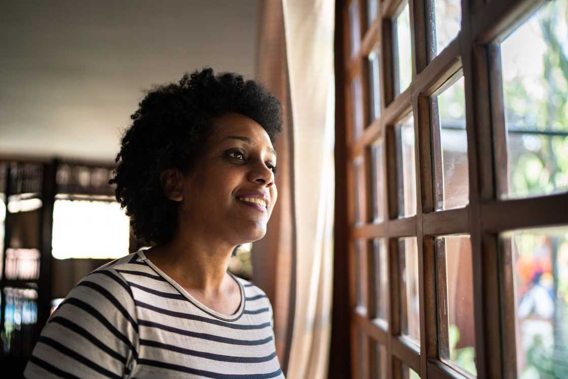 A lady reflecting by the window