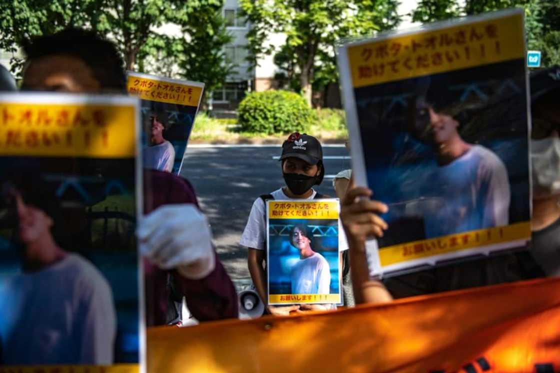 A group of activists hold placards of Japanese journalists Toru Kubota, who will be released from prison, according to a junta official