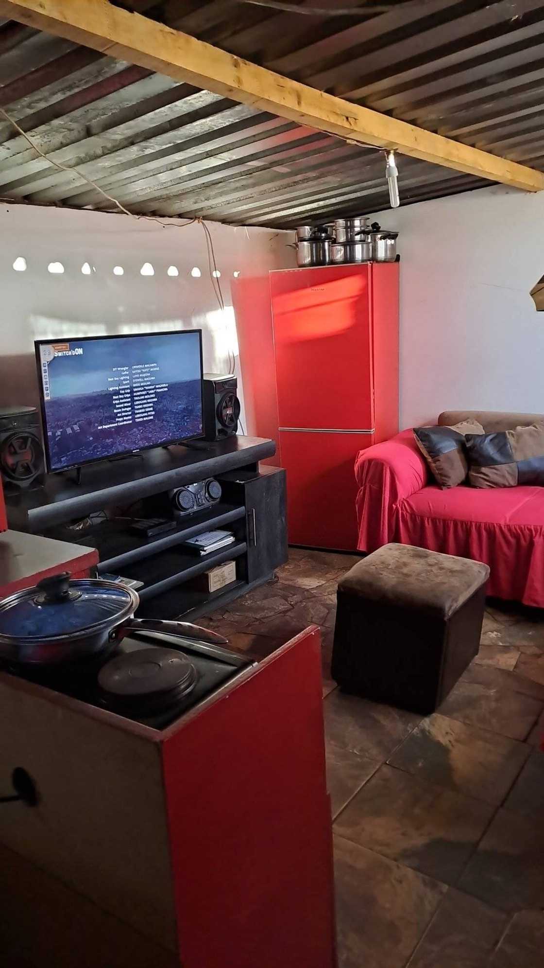 Woman shows off her kitchen and lounge space. Woman shows off her kitchen and lounge space.