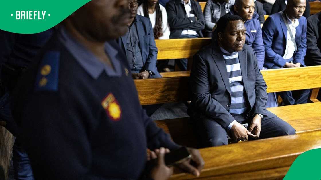 Suspended South African National Police Commissioner General Fannie Masemola (R) sits as he appears for charges linked to an irregular Medicare24 police tender, at the Pretoria Magistrate's Court in Pretoria on May 13, 2026 Suspended South African National Police Commissioner General Fannie Masemola (R) sits as he appears for charges linked to an irregular Medicare24 police tender, at the Pretoria Magistrate's Court in Pretoria on May 13, 2026