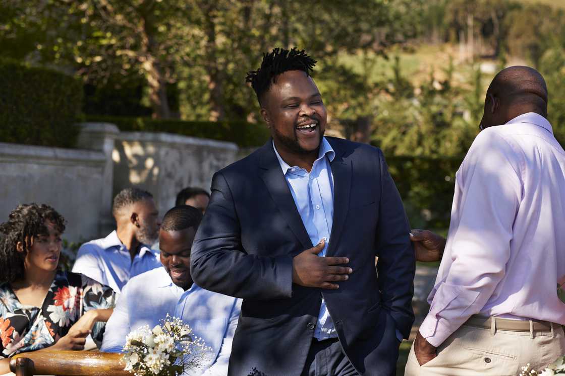 A man in formals standing during a wedding ceremony
