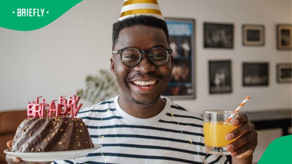 A stock photo of a man with a birthday cake and juice