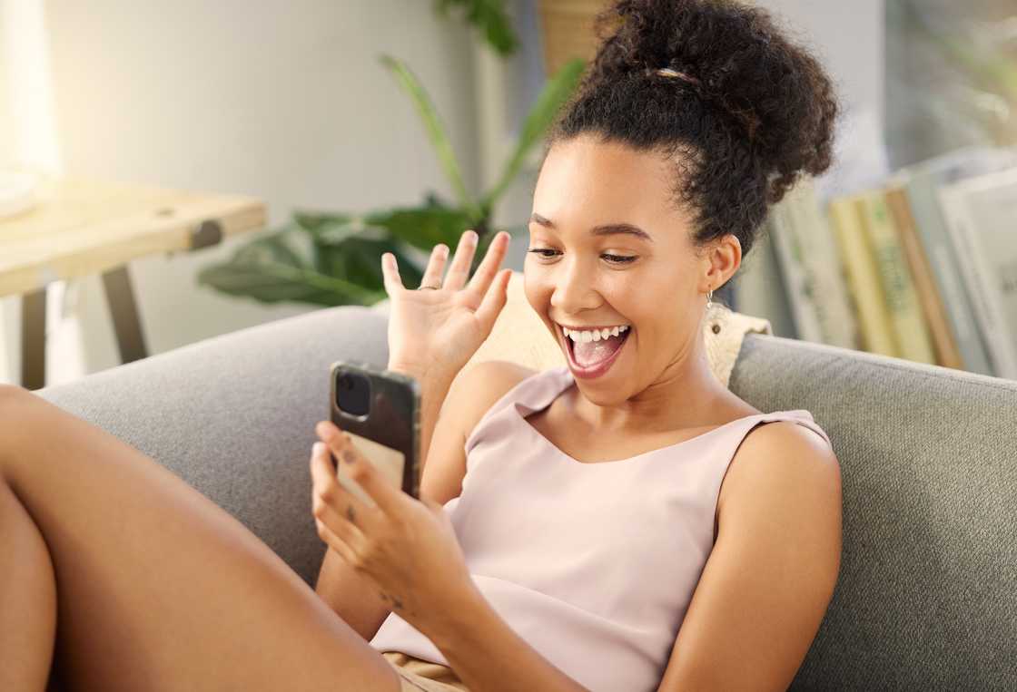 A woman smiling at her phone. A woman smiling at her phone.