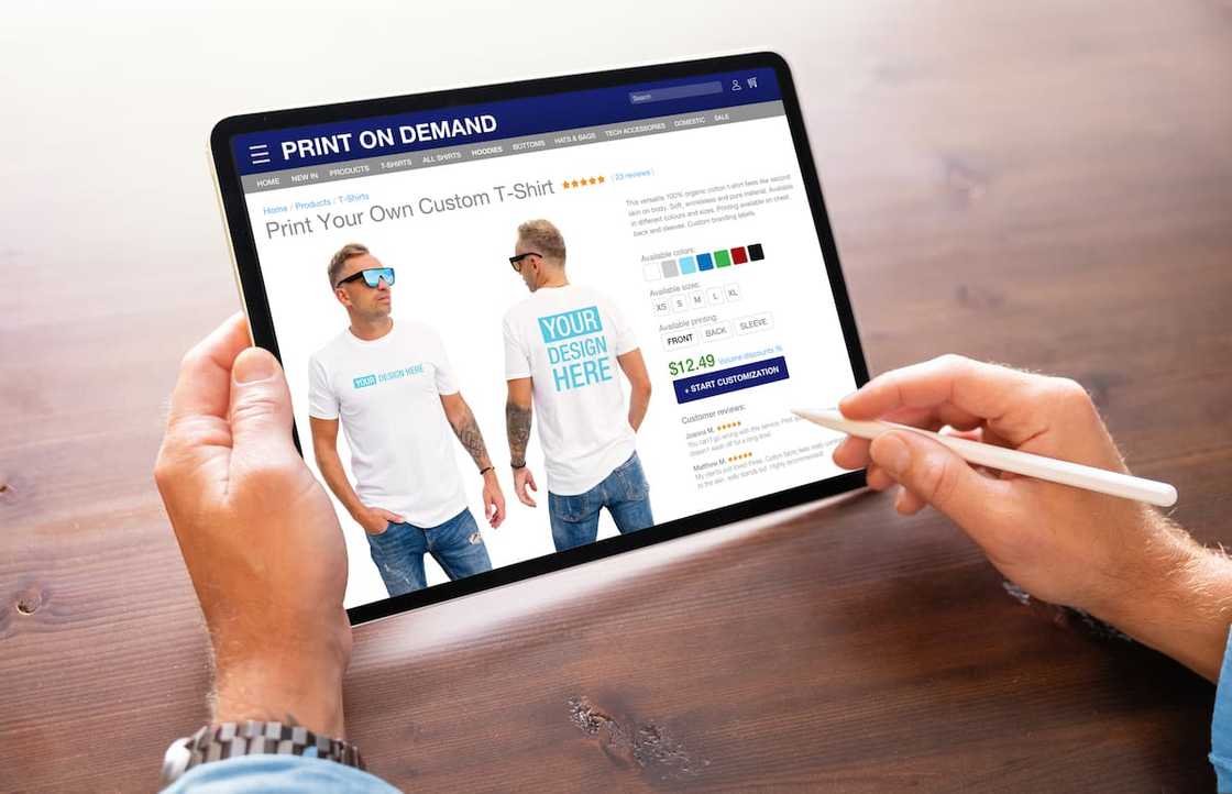 A man creating custom design t-shirts on Print-on-Demand service website A man creating custom design t-shirts on Print-on-Demand service website