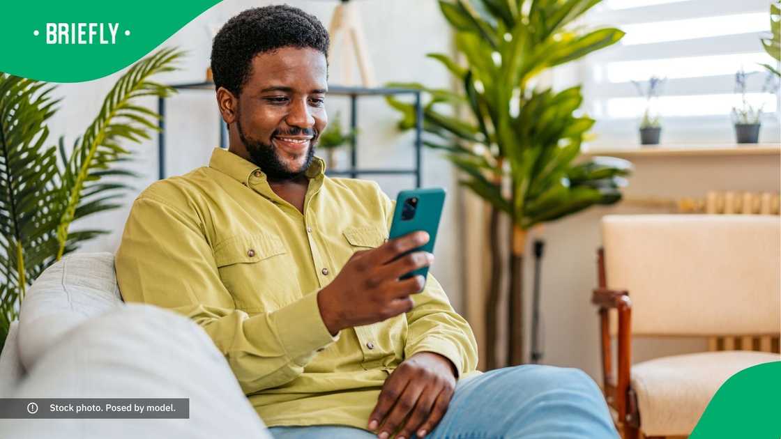 A man smiling at his phone. A man smiling at his phone.