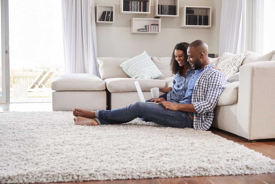 Black and woman sit down on the rug