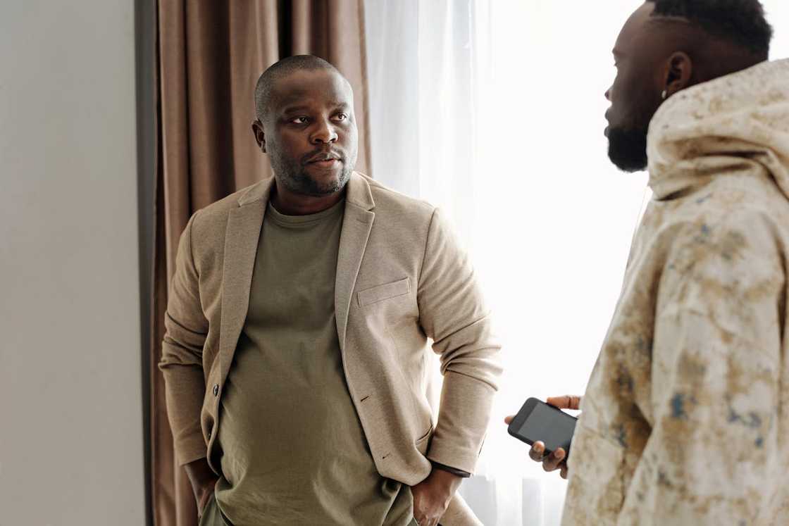 Two men talk in a modest living room. Two men talk in a modest living room.