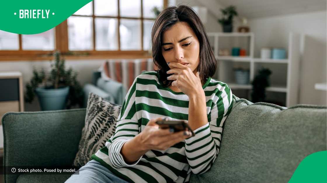 A confused woman looking at her phone. A confused woman looking at her phone.