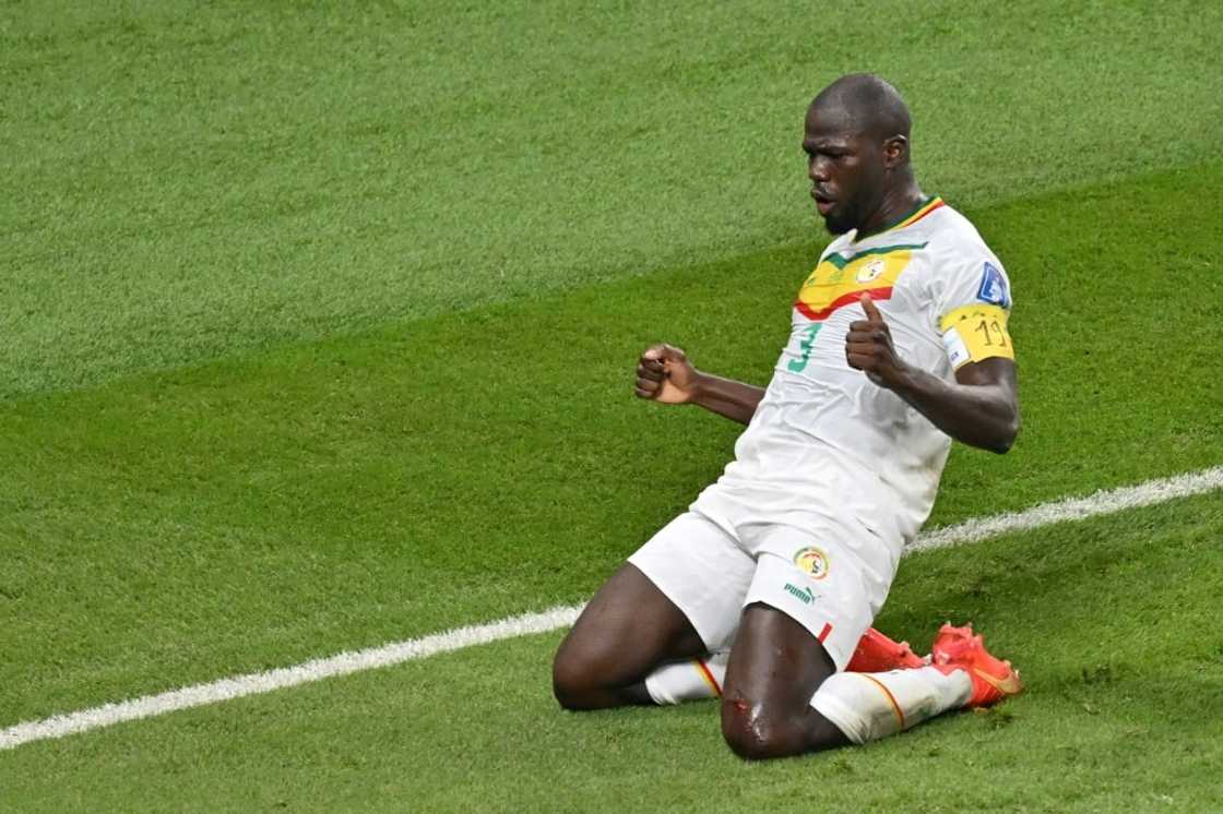 Kalidou Koulibaly celebrates scoring his team's second goal against Ecuador, wearing an armband bearing the number 19 of late Senegal player Papa Bouba Diop Kalidou Koulibaly celebrates scoring his team's second goal against Ecuador, wearing an armband bearing the number 19 of late Senegal player Papa Bouba Diop