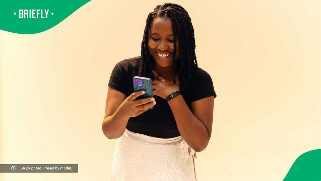 A woman smiling at her phone.