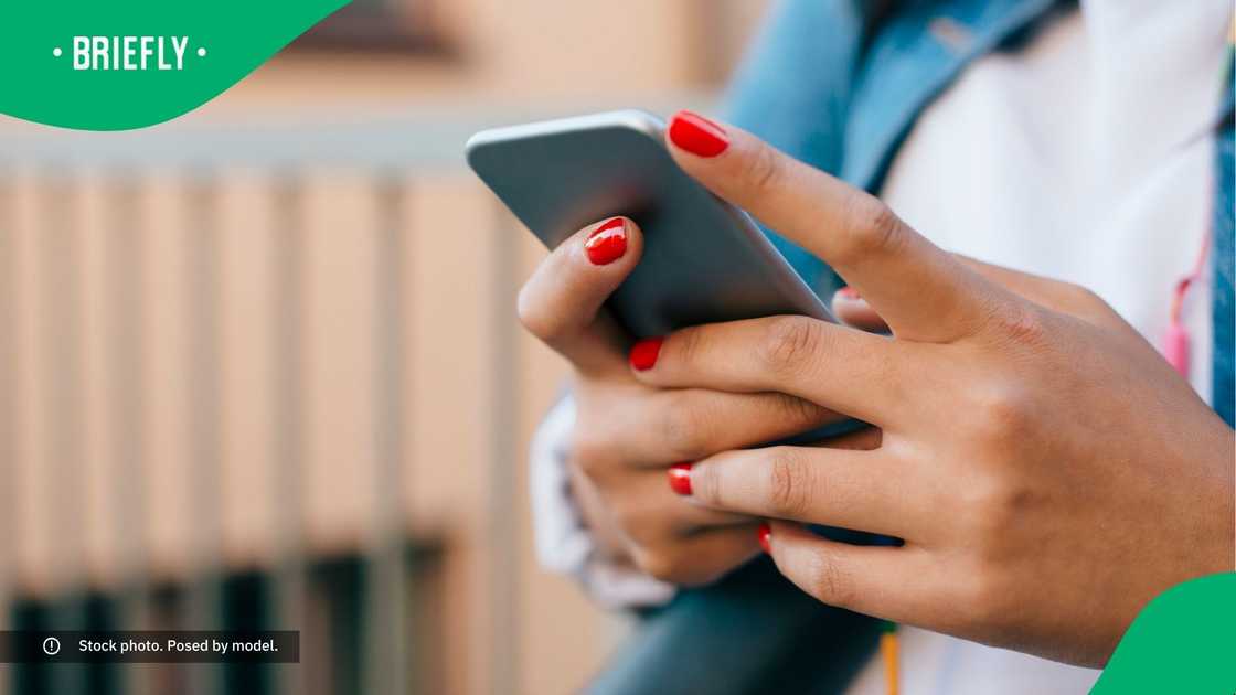 A young woman typing on her phone. A young woman typing on her phone.