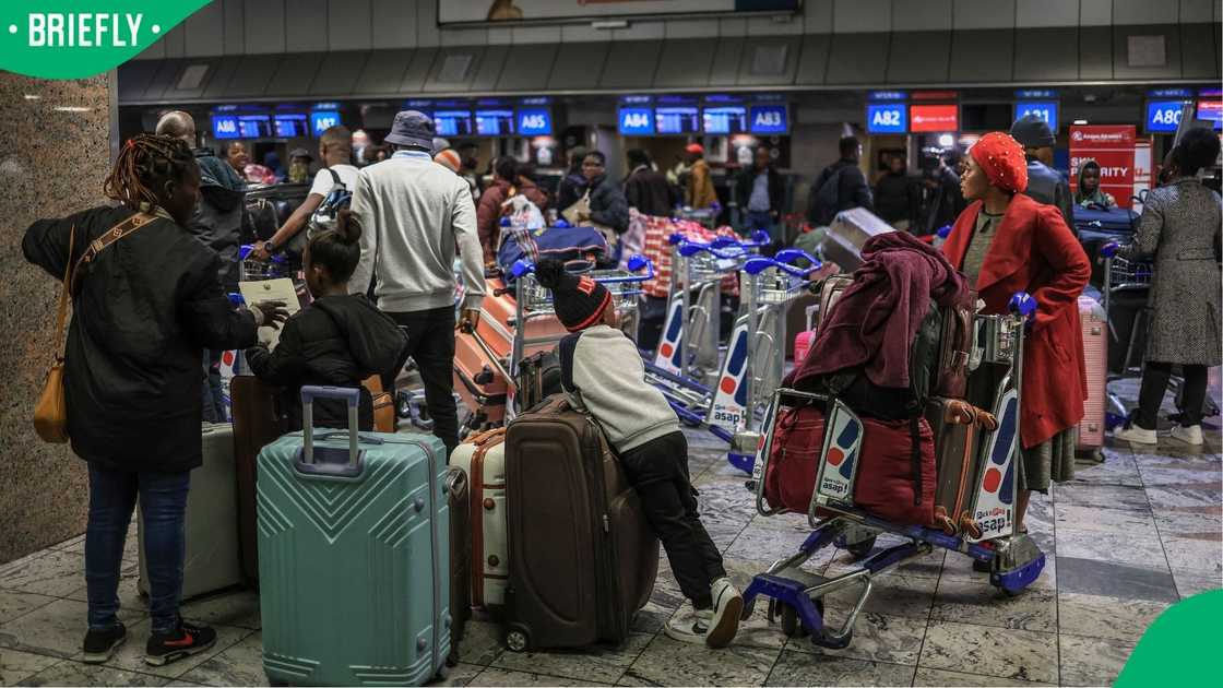 Ghanaian nationals stand at the check-in desk for an evacuation flight at OR Tambo International Airport Ghanaian nationals stand at the check-in desk for an evacuation flight at OR Tambo International Airport