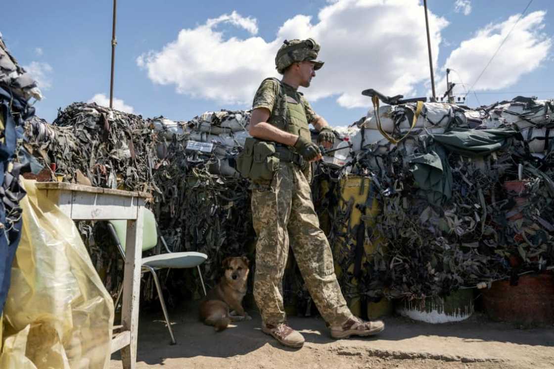 A small detachment of Ukrainian soldiers holds the position in sandbagged trenches and the wreckage of destroyed buildings