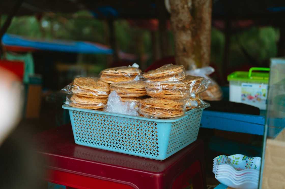 Stacked flatbreads are packed in plastic at a small market stall. Stacked flatbreads are packed in plastic at a small market stall.