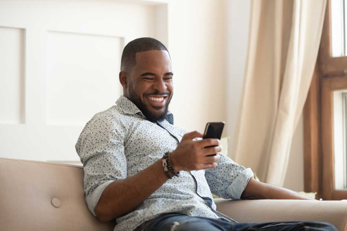 A man laughing at his phone.