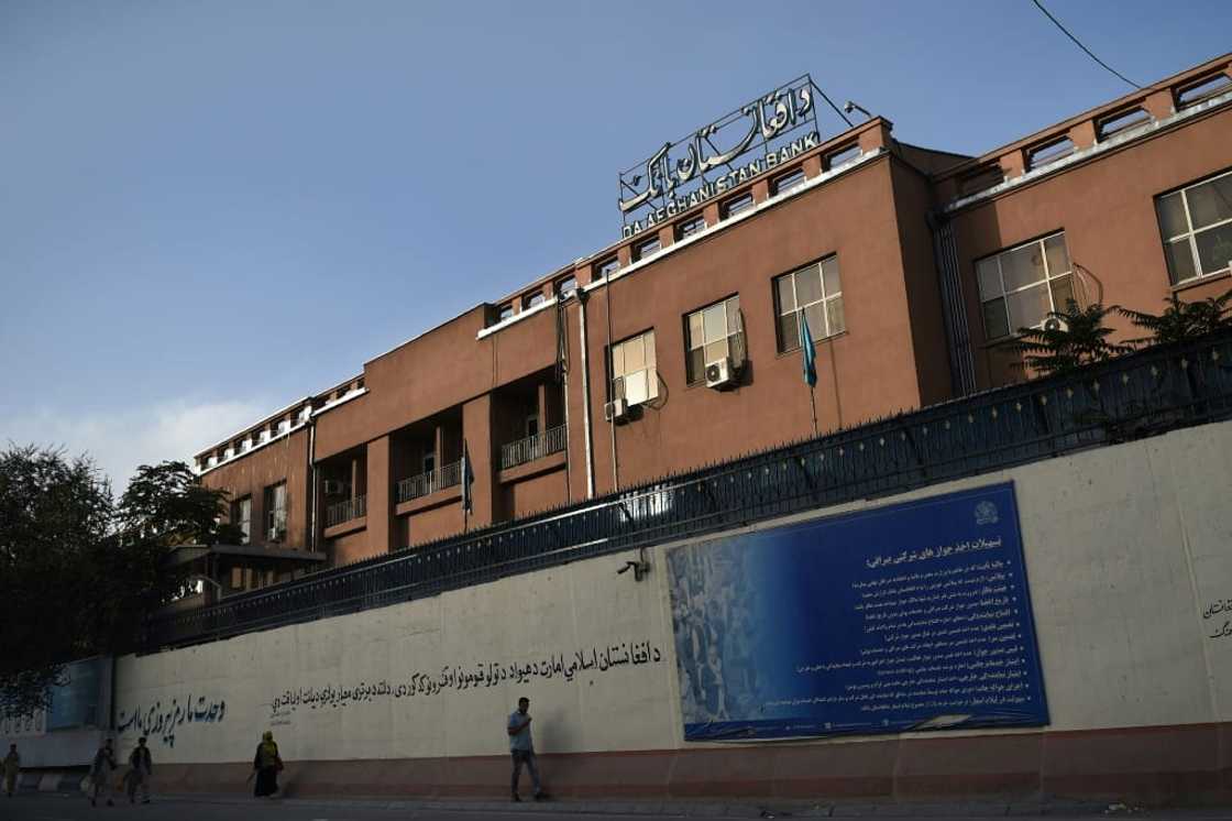 Kabul residents walk in October 2021 past the central Da Afghanistan Bank, which the United States has decided to sideline in administering the country's reserves following the Taliban takeover