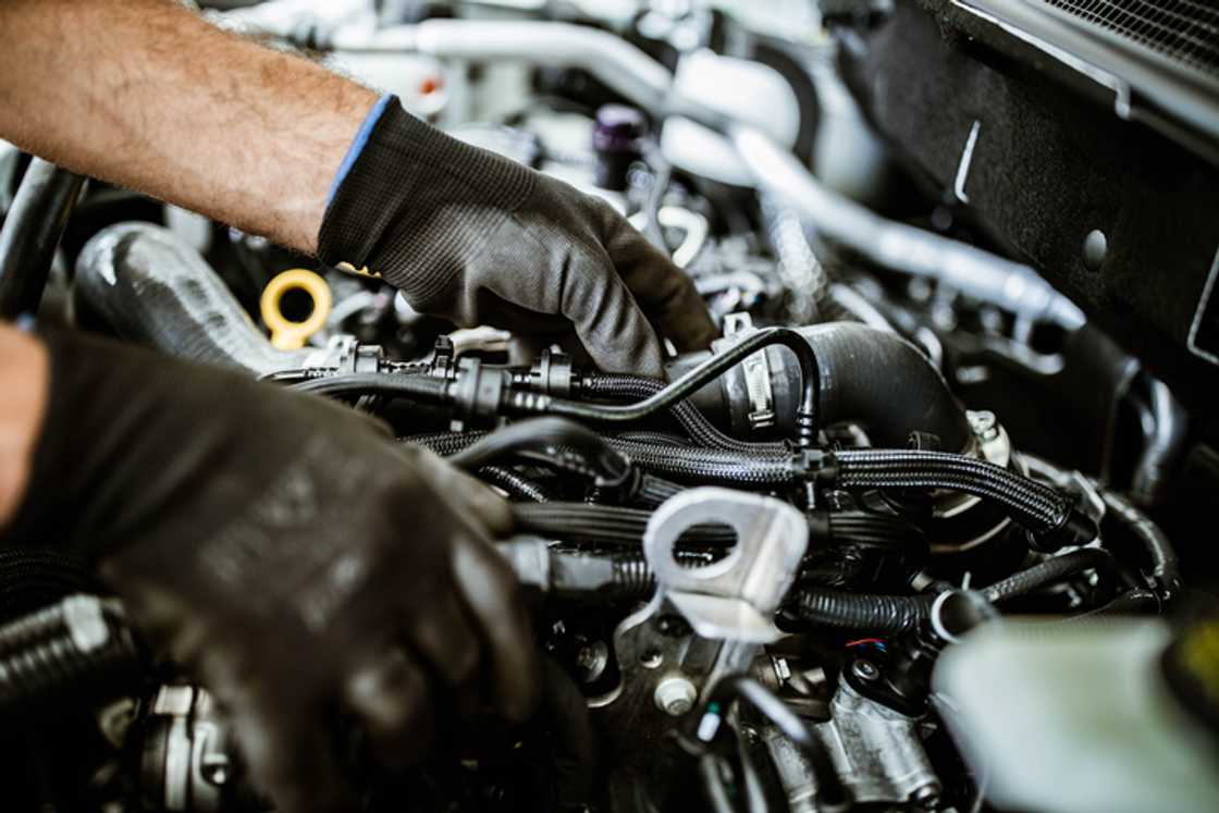 A mechanic working on a car pump at a workshop