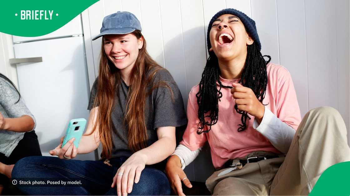 People laughing at content on a phone.