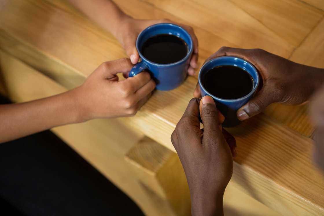 Close-up of hands around a coffee mug. Close-up of hands around a coffee mug.