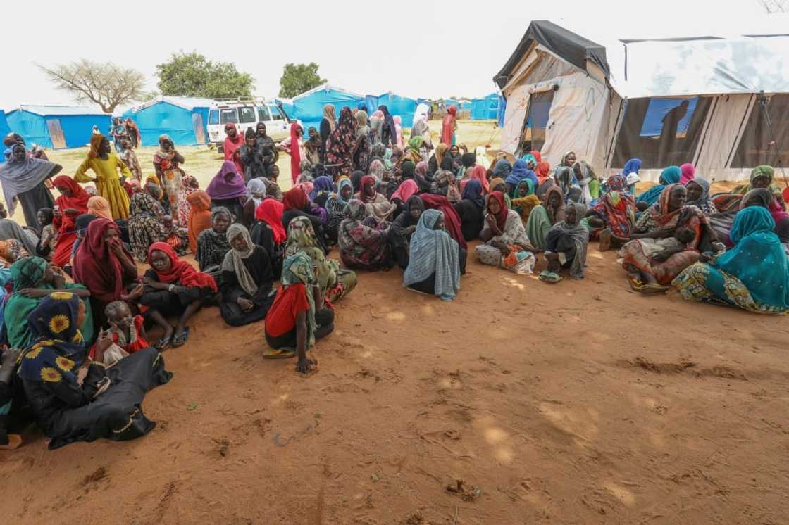 Women who fled the war in Sudan await the distribution of international aid rations at the Ourang refugee camp, near Adre town in eastern Chad on August 15, 2023