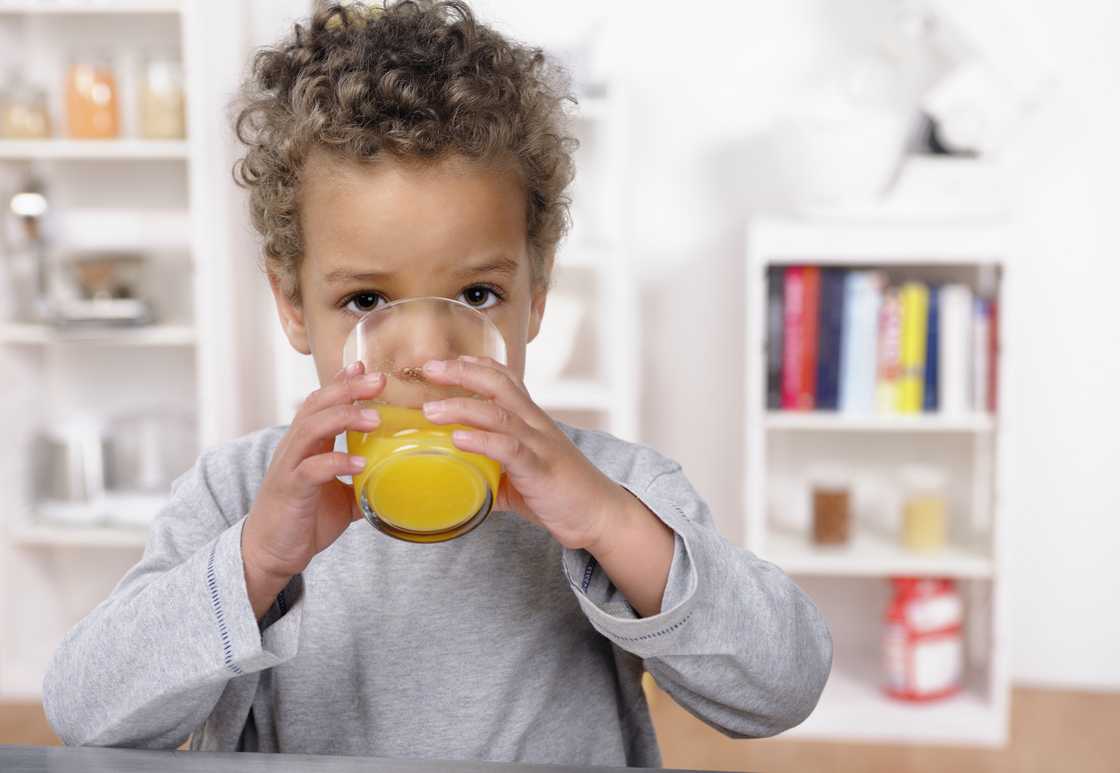 A toddler drinking juice.