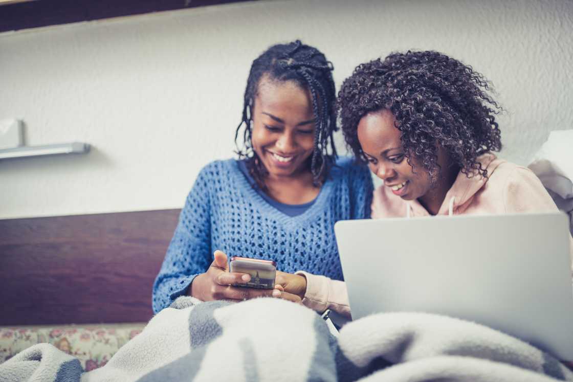Two young women studying together in a cosy university dorm room. Two young women studying together in a cosy university dorm room.