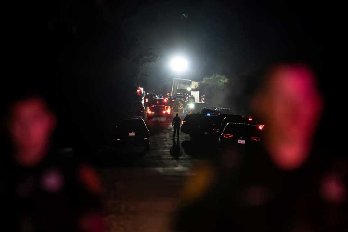 A first responder walks through the scene where a tractor-trailer was discovered with dozens of dead migrants  outside San Antonio, Texas; 50 deaths have been confirmed. A first responder walks through the scene where a tractor-trailer was discovered with dozens of dead migrants  outside San Antonio, Texas; 50 deaths have been confirmed.