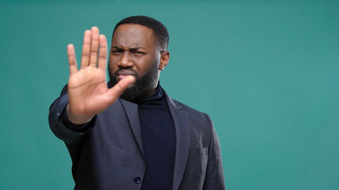 A serious man denying entry using gestures