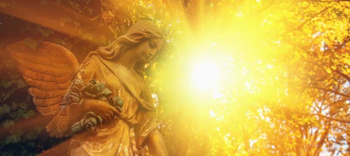 The statue of a guardian angel in sunlight The statue of a guardian angel in sunlight