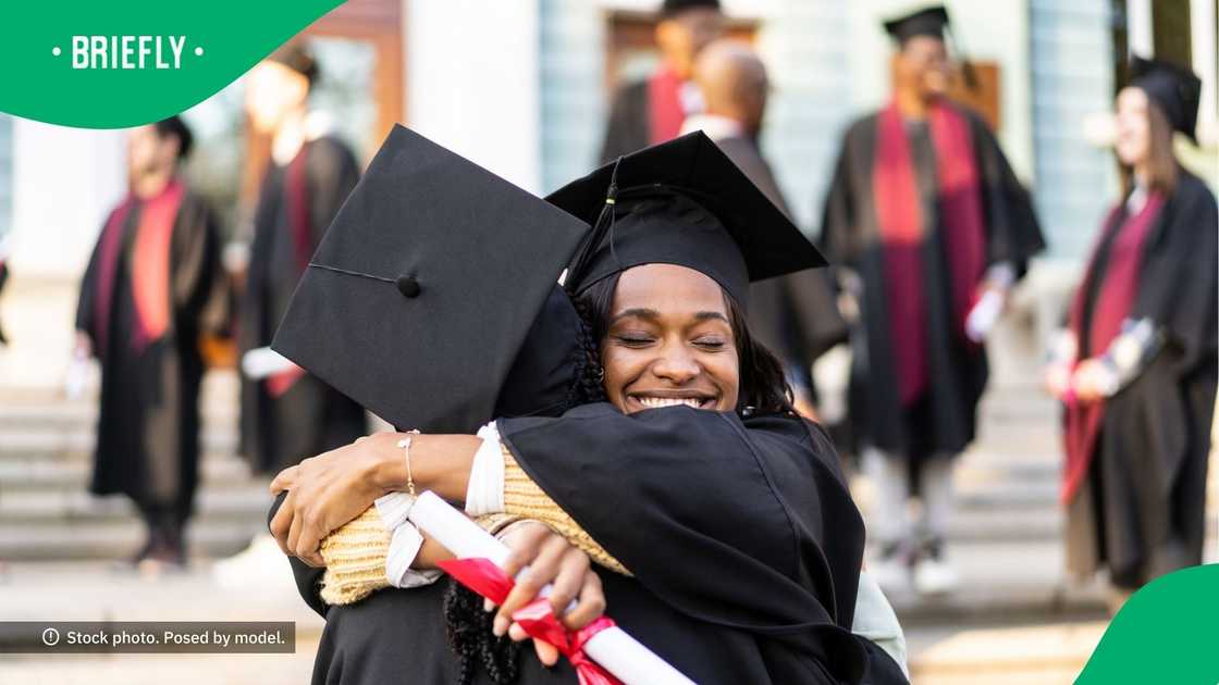 Two graduates hugging each other.