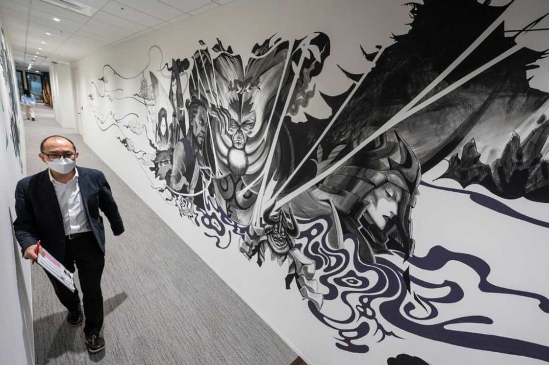 A Netflix employee walks past an anime mural at the company's Tokyo offices A Netflix employee walks past an anime mural at the company's Tokyo offices